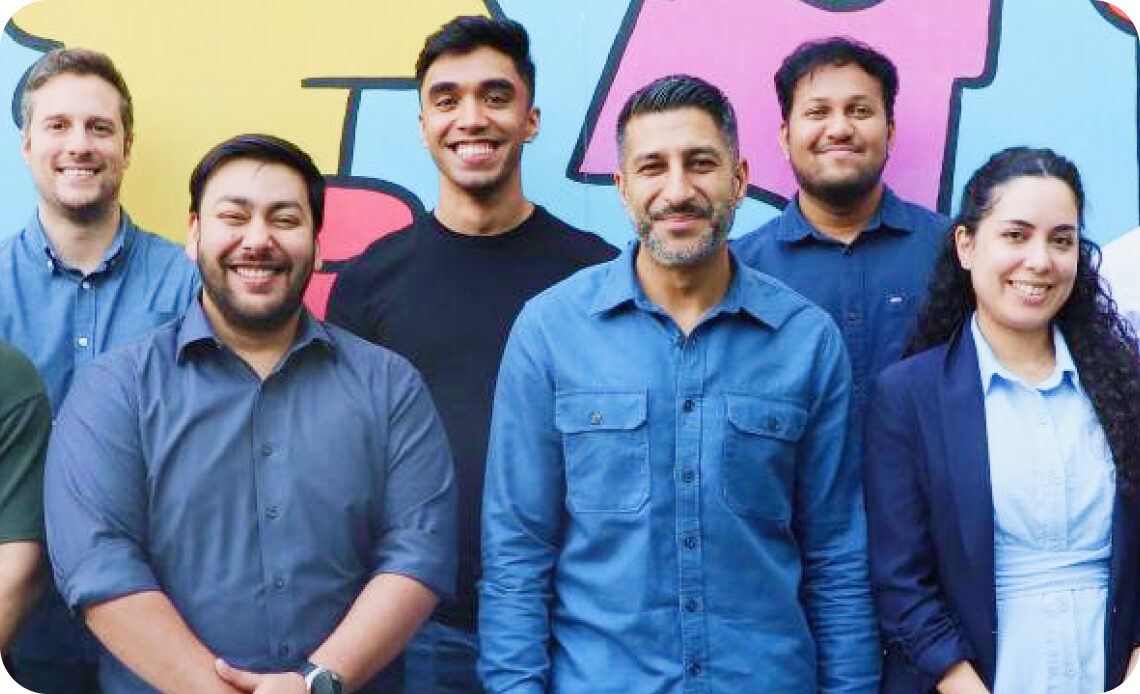 Group of Omnicom colleagues posing in front of a colorful mural