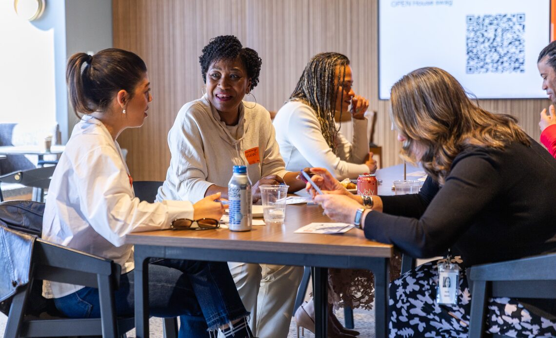 A group of Omnicom colleagues in discussion around a meeting table